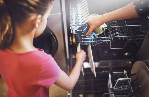これはきれいに見えます 家庭で食器洗い機で皿を詰める認識できない女の子の肩のショットの上に — ストック写真