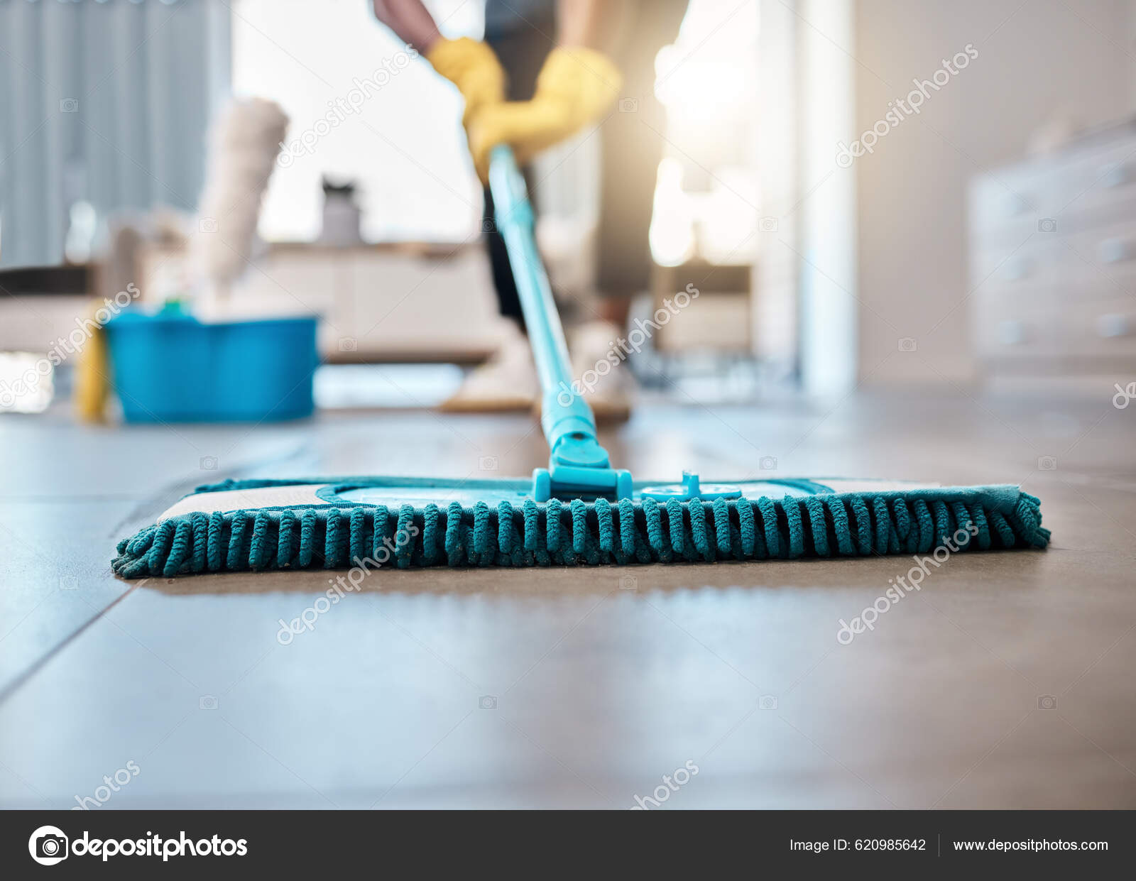 Detergente de limpieza y trapeador en el piso de una sala de estar en un  hogar