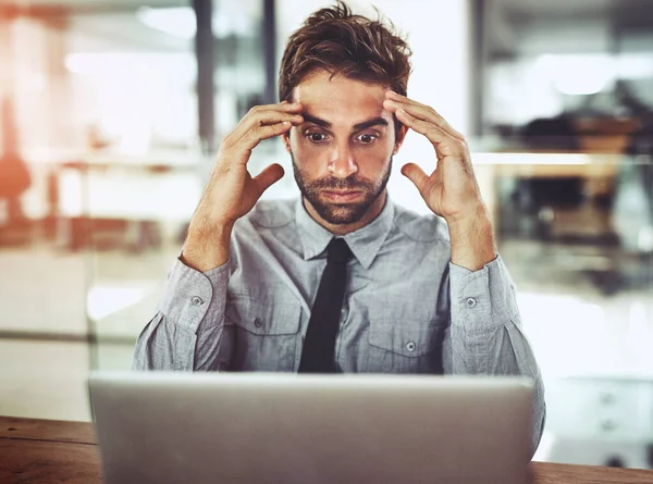 オフィスのノートパソコンで仕事をしながらストレスを感じているハンサムな若いビジネスマン — ストック写真
