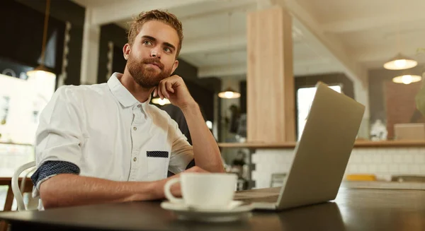 彼には将来への大きな計画がある カフェのノートパソコンの前に座っている若い男が — ストック写真