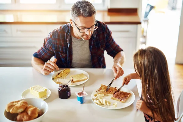 给我来点 一个可爱的小女孩和她爸爸在厨房吃早餐 — 图库照片