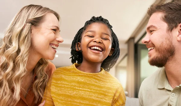 Family, adoption and parents with girl in home having fun, laughing and bonding together on weekend. Love, multicultural and happy mom and dad with african american daughter relax in living room.