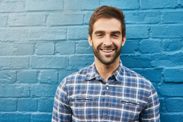 stock image Hes all charm. Portrait of a handsome young man standing against a wall