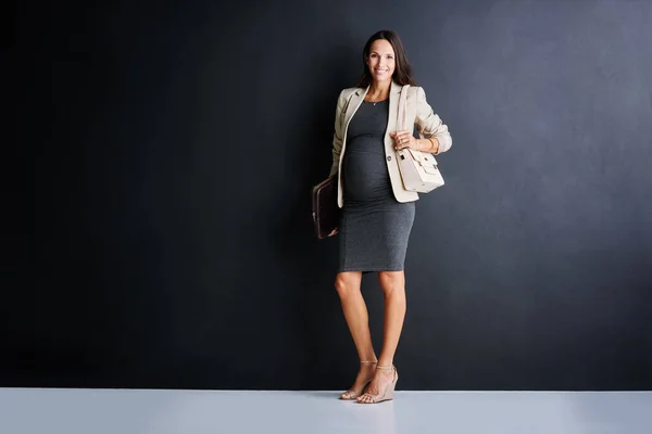 职业女性的孕产服 一个年轻的怀孕女商人站在黑色背景下的工作室肖像 — 图库照片
