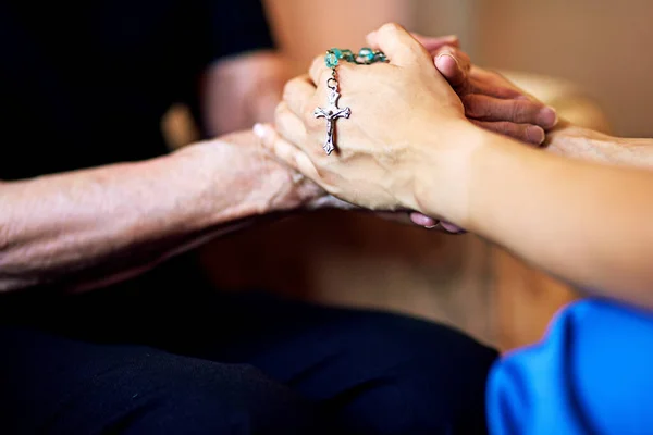 让我们一起祈祷吧牵着念珠和老年妇女的手的人 — 图库照片#