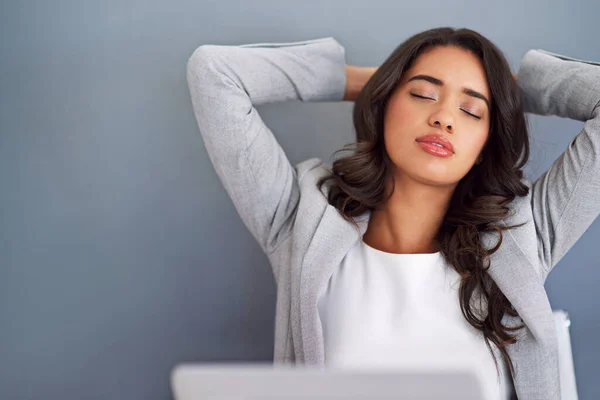 stock image Looks like a relaxed day in the office. a young businesswoman looking relaxed while working on her laptop