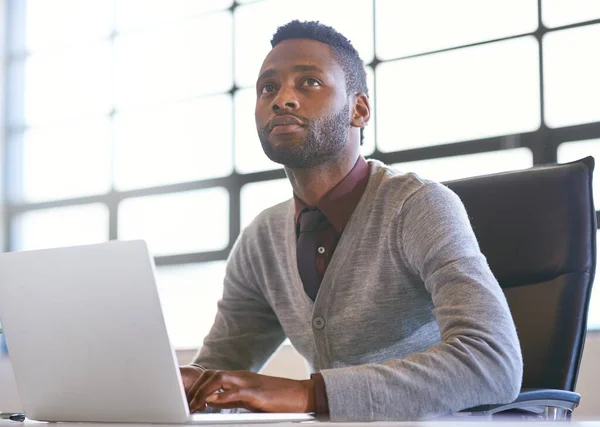 在网上搜寻另一个赚钱的商机 一个有思想的年轻商人在办公室里用笔记本电脑 — 图库照片