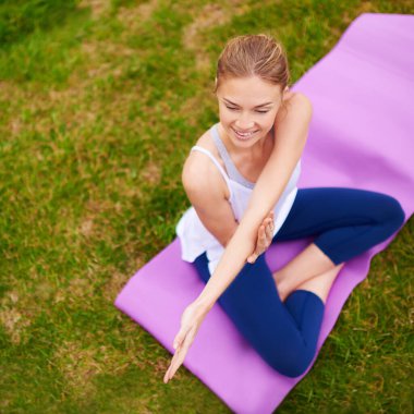 Kendine iyi davranmanla ilgili. Dışarıda yoga yapan genç bir kadın.