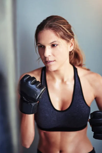 彼女には力がある パンチングバッグ付きの女子ボクサーのトレーニング — ストック写真