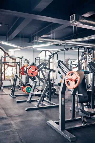 Gym, equipment and weights of fitness background for exercise, training or heavy workout for strength building and wellness. Empty health club of interior space and machines or tools for exercising.