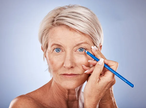 美容美发 妆容成熟的女人 背景为蓝眼睛用的眼线铅笔 化妆品和护肤 一个漂亮的老年女士的肖像与豪华化妆品在脸上的应用 — 图库照片