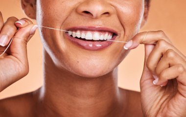 Kadın, diş ipi, cilt bakımı ya da kişisel hijyen için gülümseyen eller ve dişler. Oral, ağız ya da sakız bakımı için kozmetik bölümünde gülümseyen ve diş ipi kullanan kadınlara yakın çekim.