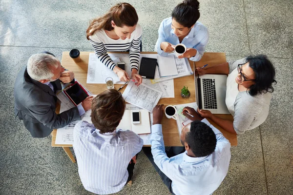 stock image Planning starts in the boardroom. High angle shot of a group of coworkers sitting around a table in the boardroom