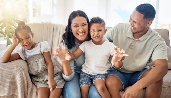 Love, black family and being happy, silly and have fun together on couch in living room. Parents, mother and father with children, happiness and bonding on sofa in lounge for quality time or playful.