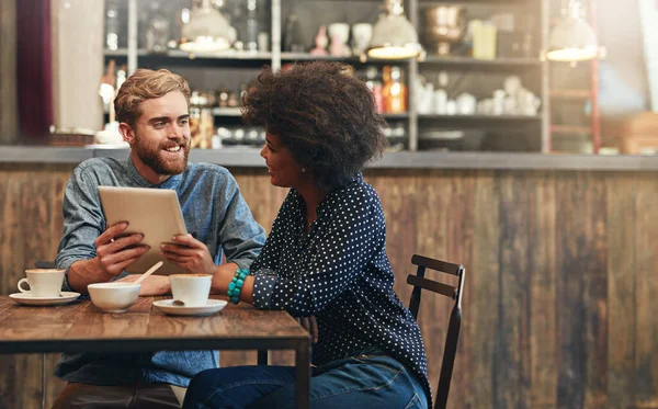 stock image This app can take us to the top. a young couple using a digital tablet together on a coffee date