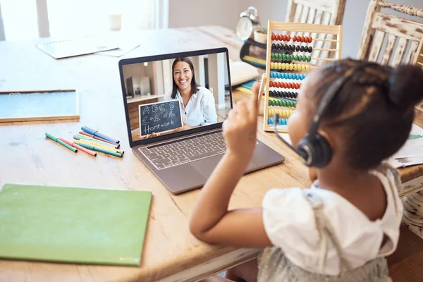 stock image Video call, online education and child with teacher for math, numbers and school teaching, learning and listening with headphones. Girl kid on laptop screen zoom call for a virtual class test at home.