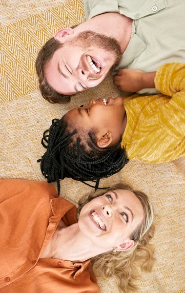 Adoption and family with girl from above lying on floor, foster family together. Mom, dad and child lying on carpet playing, love and fun time in happy family home with trust and support