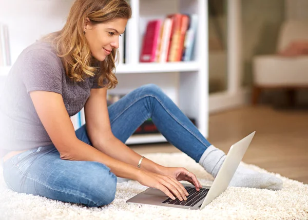 Stock image Getting in some online time. a young woman using her laptop at home