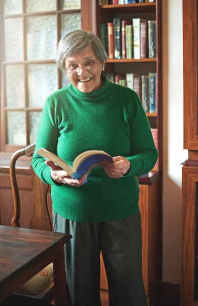 Reading keeps my mind sharp. Portrait of a smiling senior woman reading