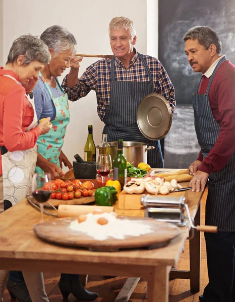 烹调使他们更亲密 一群老年人在厨房里做饭 — 图库照片