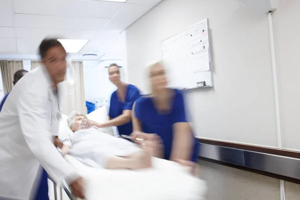 命を救うためにすぐに行動する 医者のチームが廊下を急いで — ストック写真