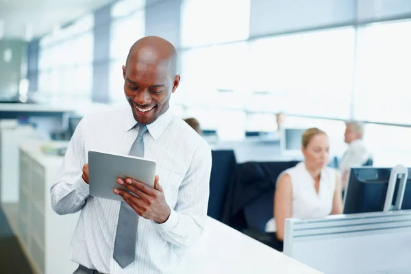 Business man using touchpad PC. Handsome business man using tablet PC with colleagues in background