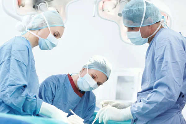 我们的工作需要很多关注 外科医生用医用钳给外科病人做手术 — 图库照片