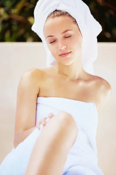 Young relaxed female in towel after a bath wrapped in a towel. Peaceful young pretty woman relaxing in towel after a bath