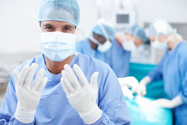 Heeling hands. Portrait of a surgical doctor holding up his hands wearing gloves before performing surgery