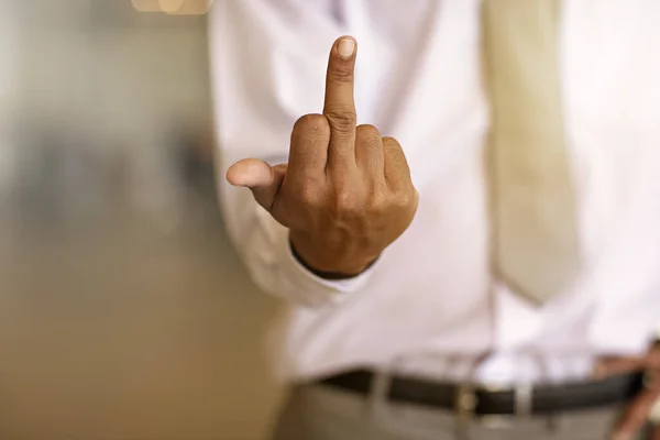 Fuck off. an unrecognizable businessman showing his middle finger