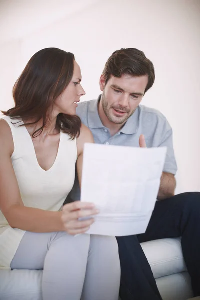 Home finances can be tricky. A married couple having a serious discussion about their home finances while inspecting a bill