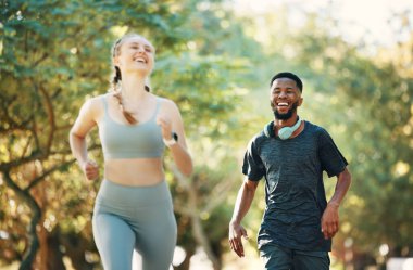 Spor yapmak ya da spor yapmak için parkta koşan, spor yapan ve eğlenen bir çift. Kardiyo sporlarında erkek ve kadın koşucuyla sağlık, eğitim ve kahkaha..