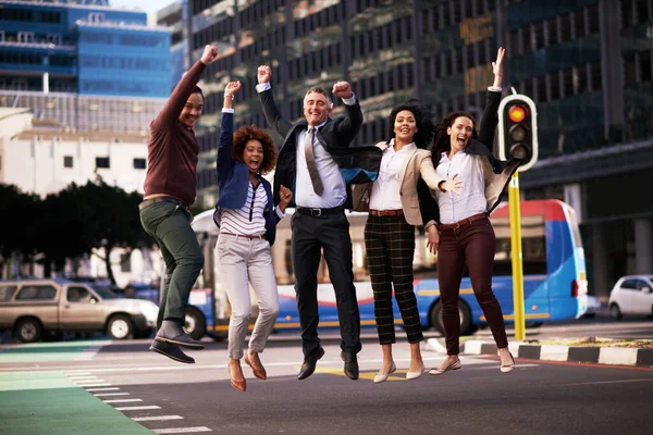 Jump if youre in the best team ever. a motivated business team jumping in the air outside in the middle of a street