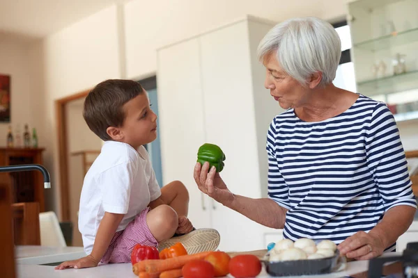 Fresh from grandmas garden. a grandmother preparing dinner with her grandchild in a kitchen