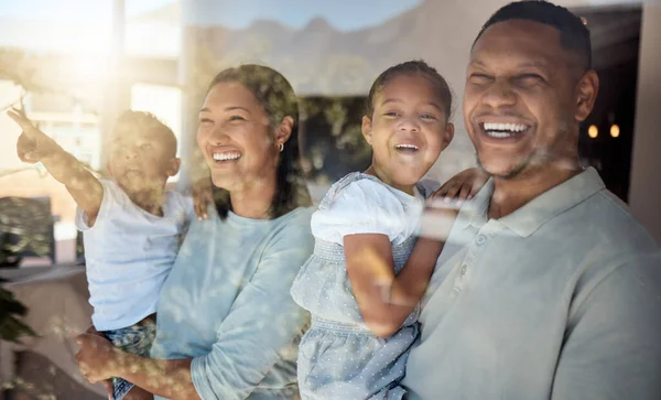 Love, home window and happy family pointing at view while laughing, bonding or enjoy relax quality time. Glass reflection, sun flare and black family care of child, mother and father excited together.