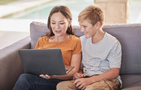 Mother, son and laptop watching movie, online and subscription, relax and happy on sofa together in home. Mom, boy and bonding, social media and fun while browsing internet and funny meme or post.