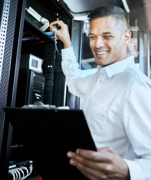 Server room, IT support and database with a man programmer working on a mainframe in a data center. Software, cyber security and innovation with a male coder at work on a cloud for host networking.
