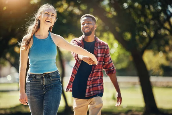緑の公園でデートに一緒に歩いている間 幸せなカップルが手をつないでいます 愛と異人種間の若い男と女性の結合しながら 新鮮な空気のための自然の中で散歩 — ストック写真