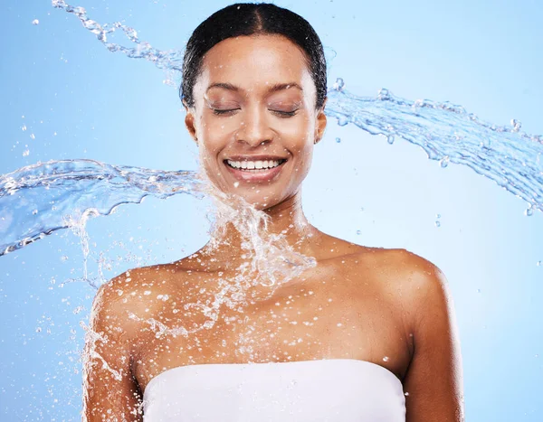 水スプラッシュとボディクリーニングと青のスタジオの背景に健康的なスキンケアと笑顔でシャワー バスルームで魅力的な若い女性の掃除ときれいな顔と水のスプラッシュ — ストック写真
