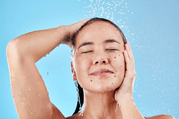 スキンケア 青の背景にシャワーで女性 朝のヘアケアと衛生ルーチン 水スプラッシュ きれいな髪ときれいな新鮮なライフスタイルのための実行中の水で顔のモデル — ストック写真