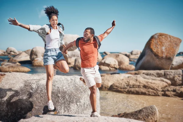 海辺の夏休みの間 ビーチ 幸せなカップルが岩の上を一緒にジャンプします メキシコの休日 冒険や旅で海によって自然の中で幸福 旅行や若い男と女 — ストック写真