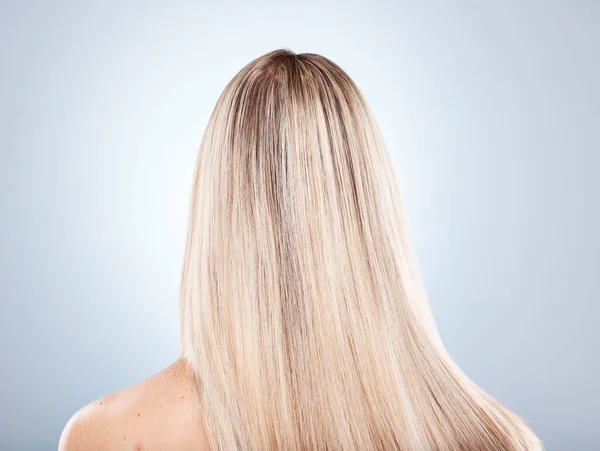 Hair, beauty and keratin with a model woman in studio on a gray background to promote a haircare product. Salon, shampoo and treatment with long, strong or healthy hair at the back of a female head.