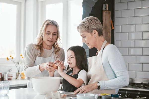 家庭での朝食のために 台所で母親と祖母との朝食 食べ物 女の子の子供と彼女の母親と家族として調理や焼きを教える上級女性 — ストック写真