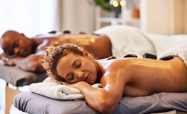 Back massage, spa stone and relax couple in luxury wellness for zen therapy, beauty and skincare. Calm, peace and sleeping people on salon bed for healthy stress relief or happy holistic body detox.