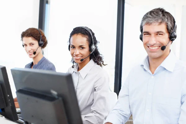 Smiling faces of customer service. Portrait of a group of call center professionals working at their computers