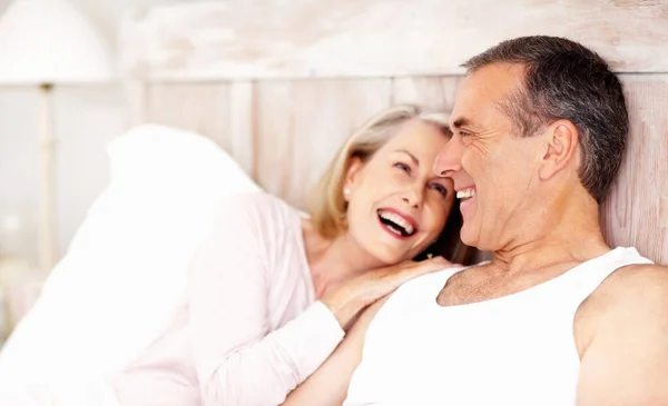 Cheerful mature couple spending time together in bed. Portrait of a cheerful mature couple spending time together in bed