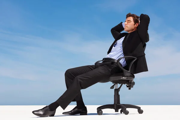 松懈的商人坐在办公椅上 在晴朗的天空下 松懈的商业主管坐在办公椅上 — 图库照片
