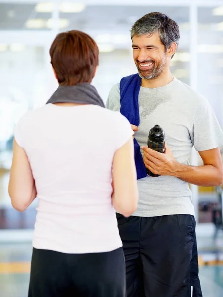 Couple at gym. Portrait of man and woman conversing at fitness center