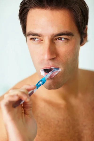 若い思慮深い男の歯をブラッシングの閉鎖 彼の歯を磨く思慮深い若い男のクローズアップ肖像画 — ストック写真