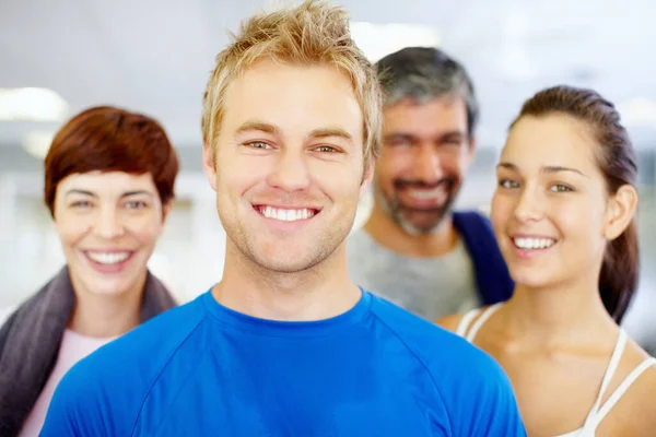 Handsome young guy at fitness center. Closeup portrait of handsome young man with his friends at fitness center